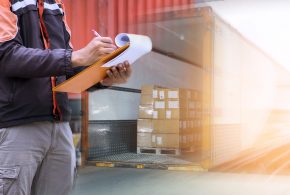Warehouse worker holding clipboard his control loading package b