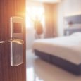 Opened door of hotel room in morning with background blurred hap