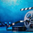 3d cinema film strip and reel with clapper board on blue