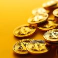 Gold Bitcoin Cryptocurrency Coins on a Yellow Background